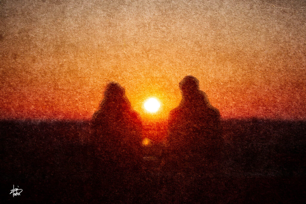 A couple watches the sunset from a park in the old town of Estonia.