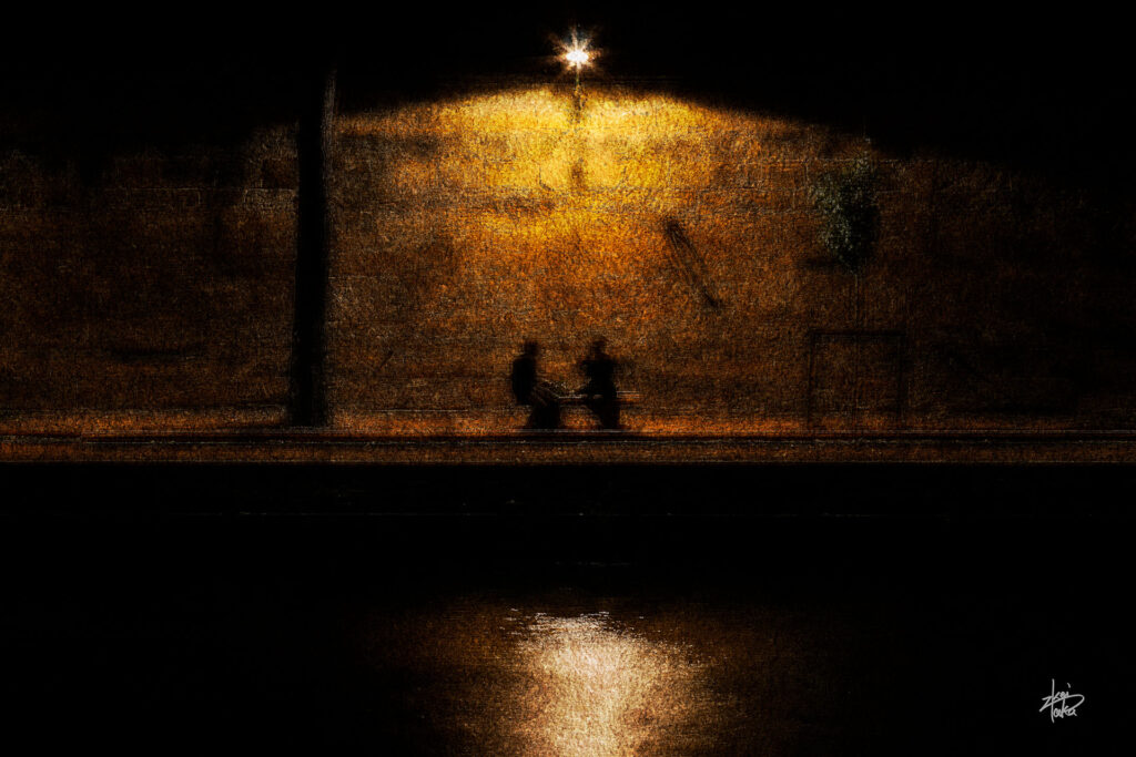 A couple enjoying conversation on the banks of the Seine at night, Paris